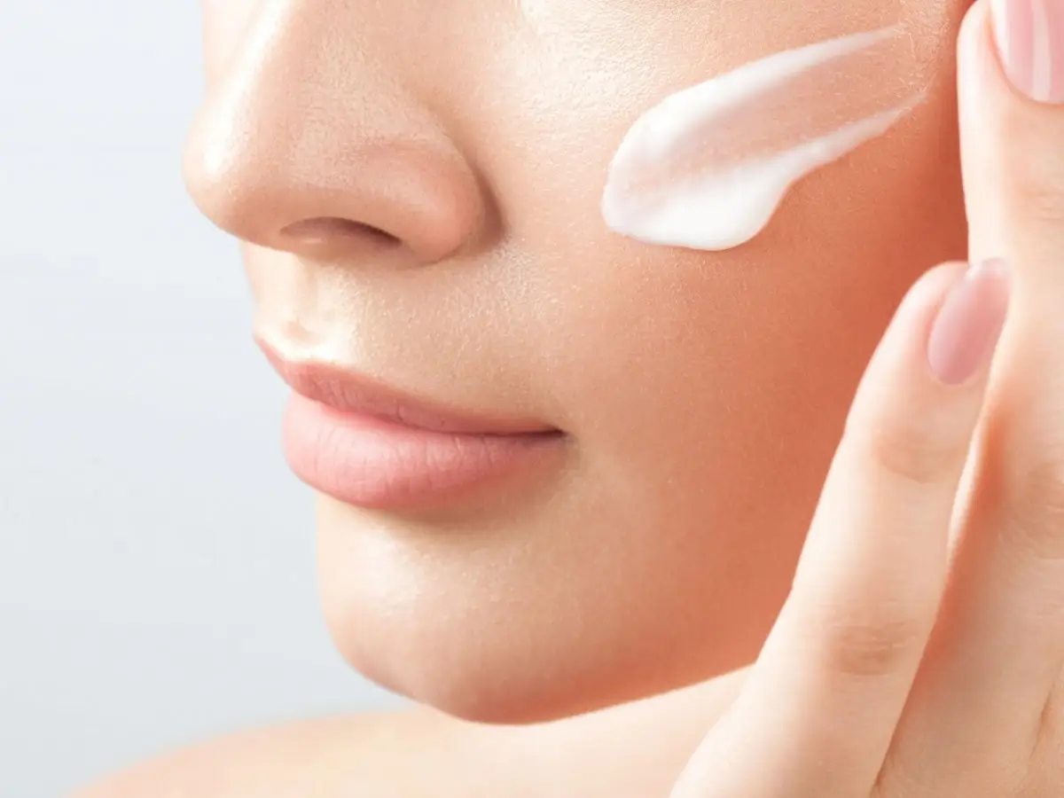 Crema aplicada sobre la mejilla de una mujer