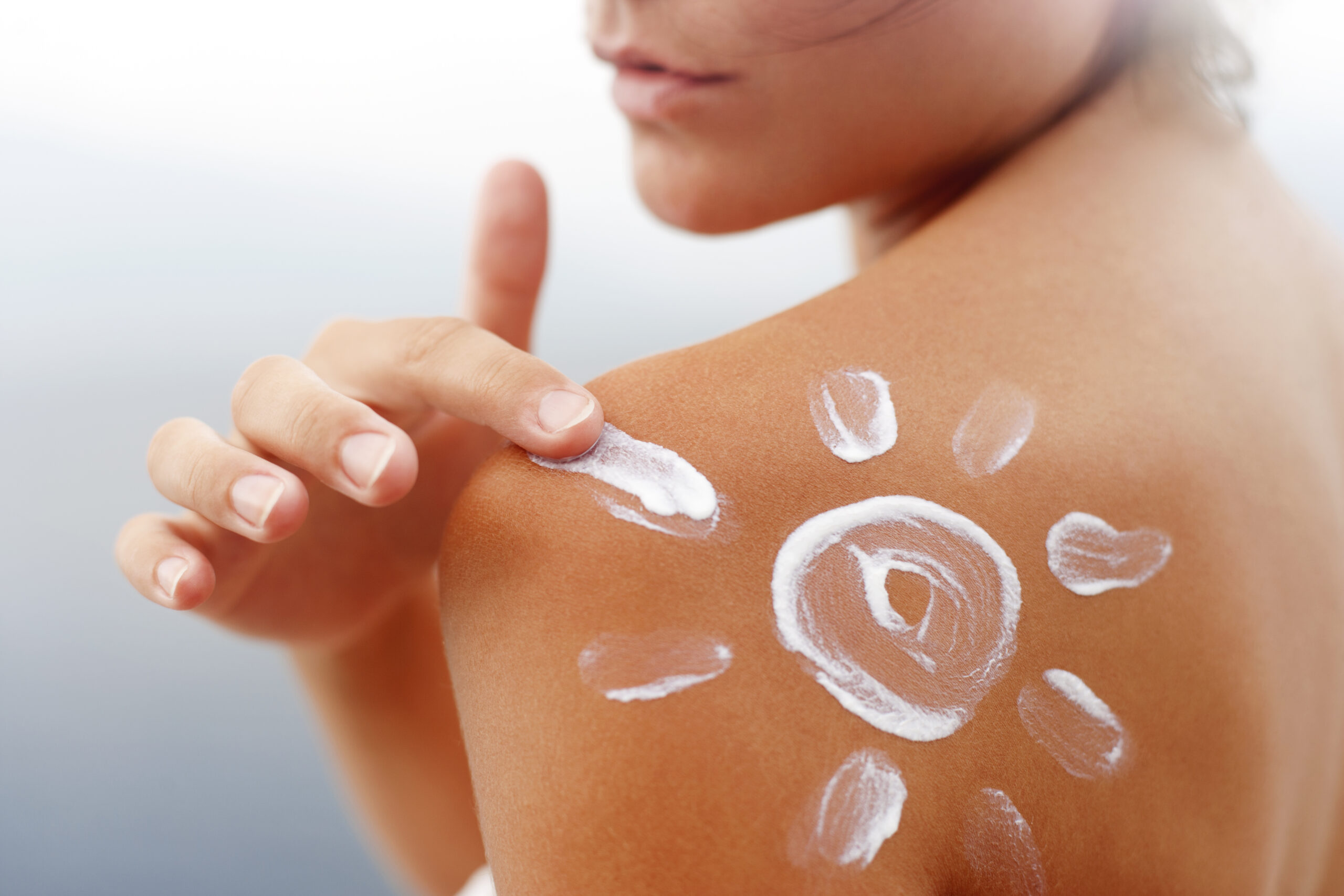 Espalda bronceada con un sol dibujado con protector solar